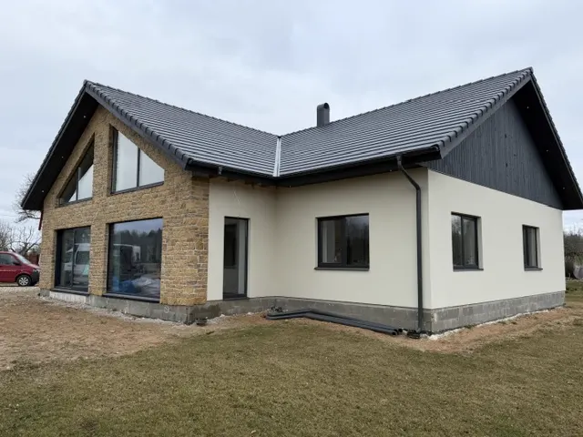 Maakivi- ja krohvifassaadiga eramu tumeda katusega