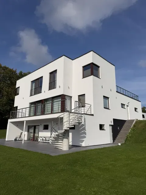 Valge kaasaegne eramu spiraaltrepi ja terrassiga
